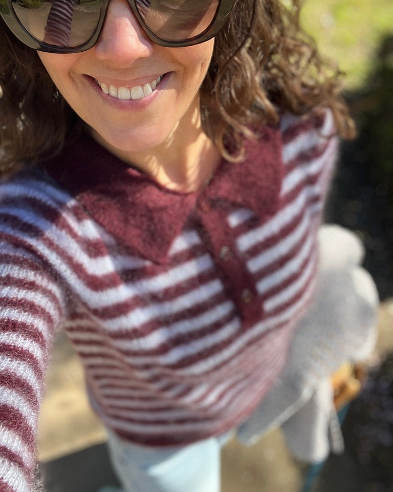 Outdoor selfie of woman in fuzzy maroon striped polo