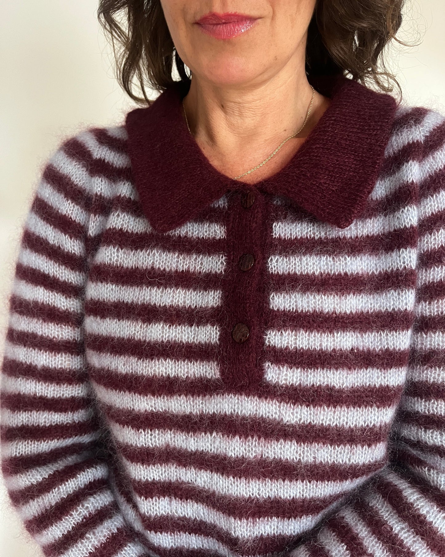 Close-up of maroon collar and buttons on striped polo