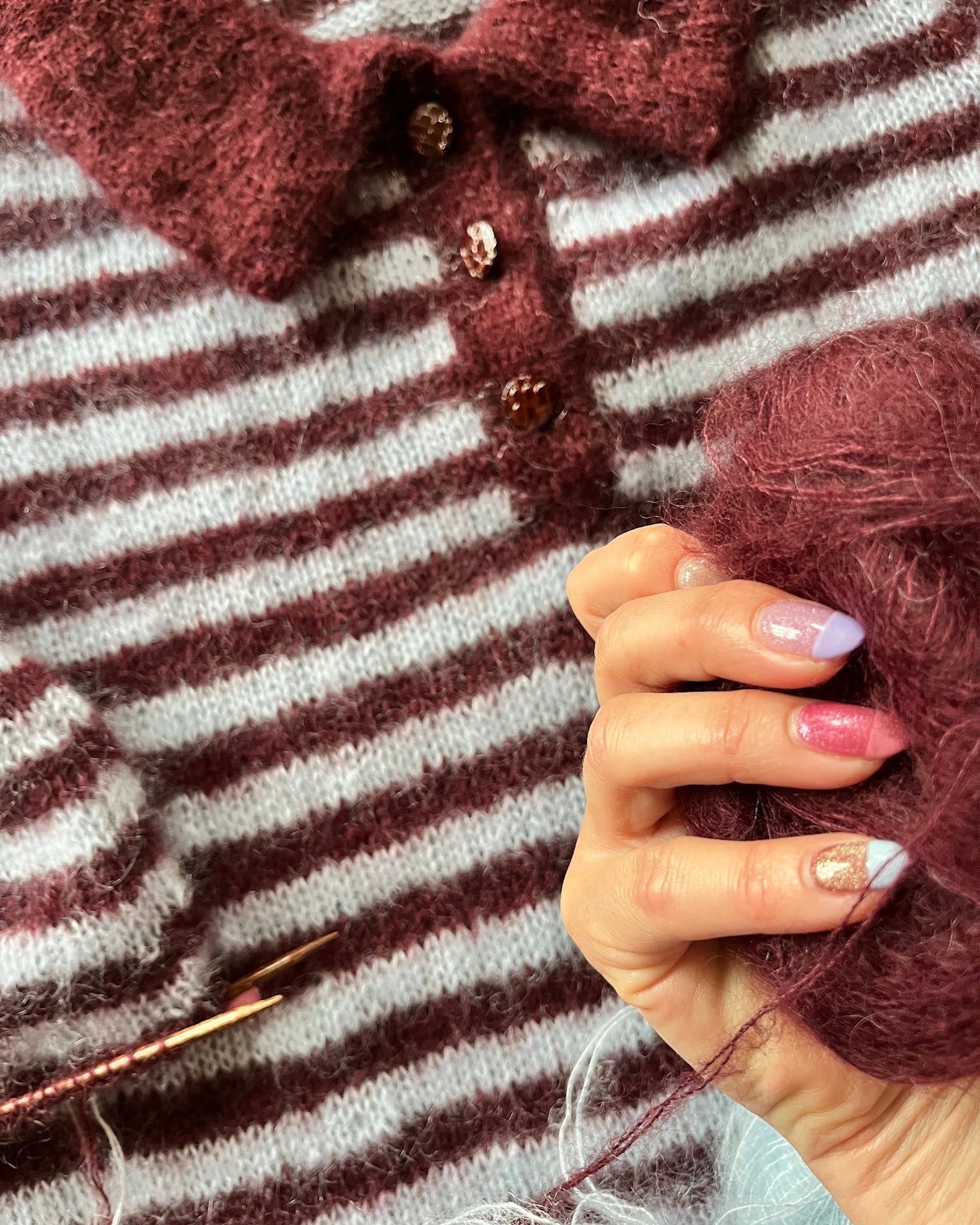 Close-up of maroon yarn and striped knitted polo texture