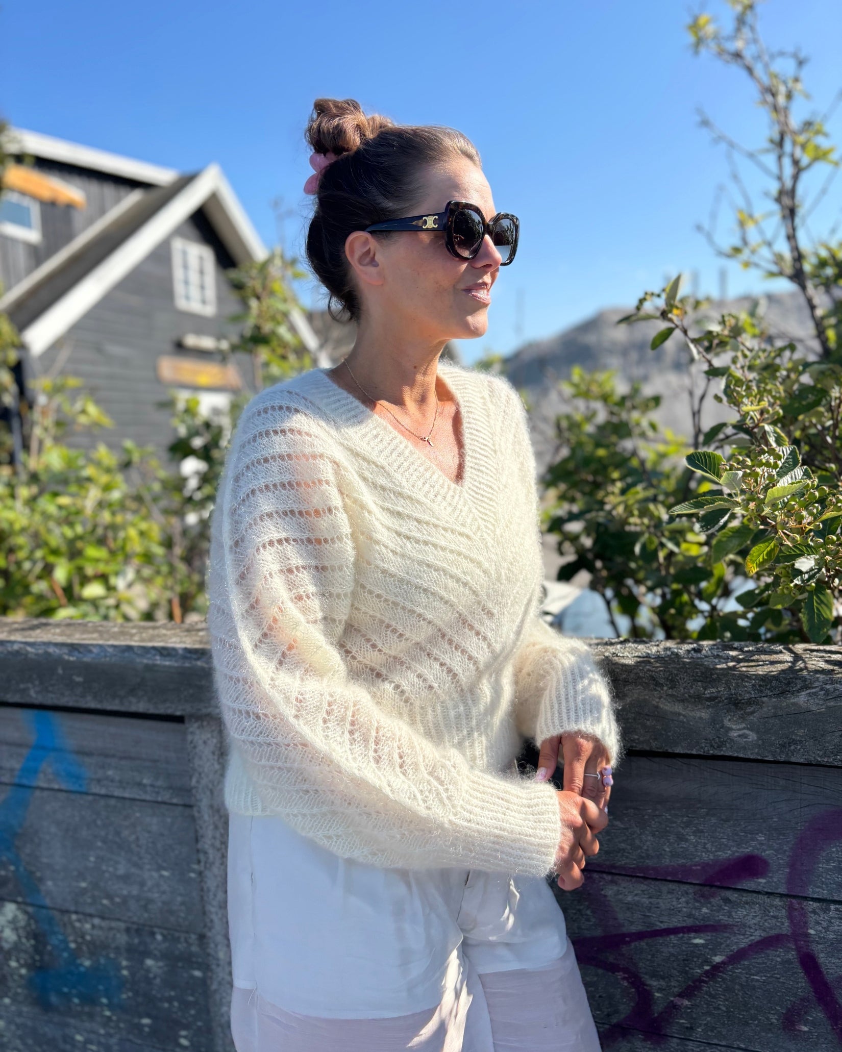 Cream fuzzy V-neck sweater with diagonal openwork and flared sleeves on model